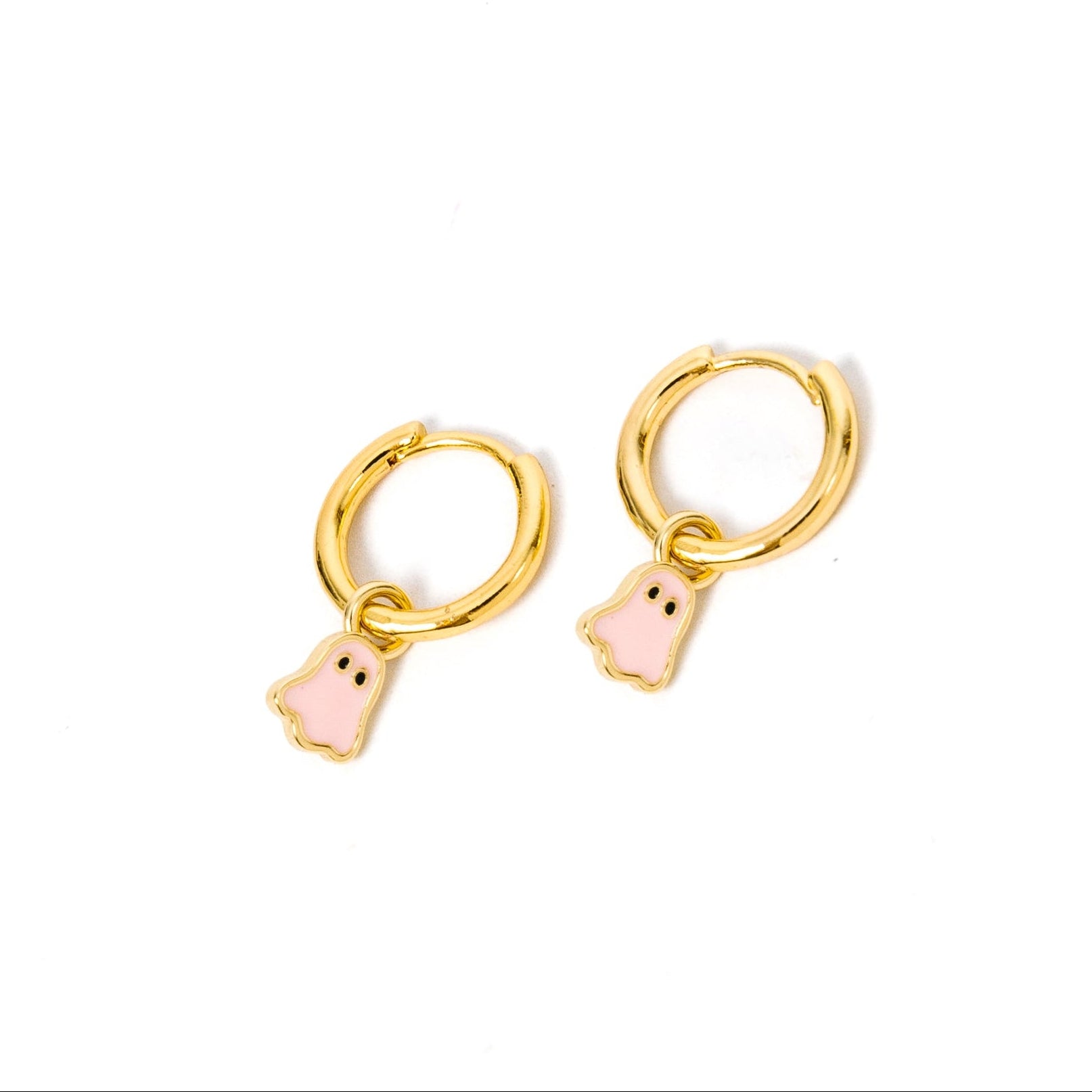 A pair of gold huggie hoop earrings with small pink ghost charms, shown on a plain white background.