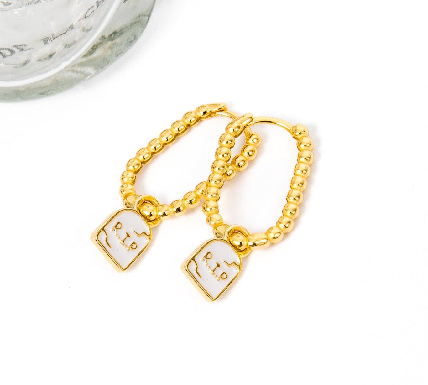 A pair of gold chain earrings with tombstone, displayed on a white background.