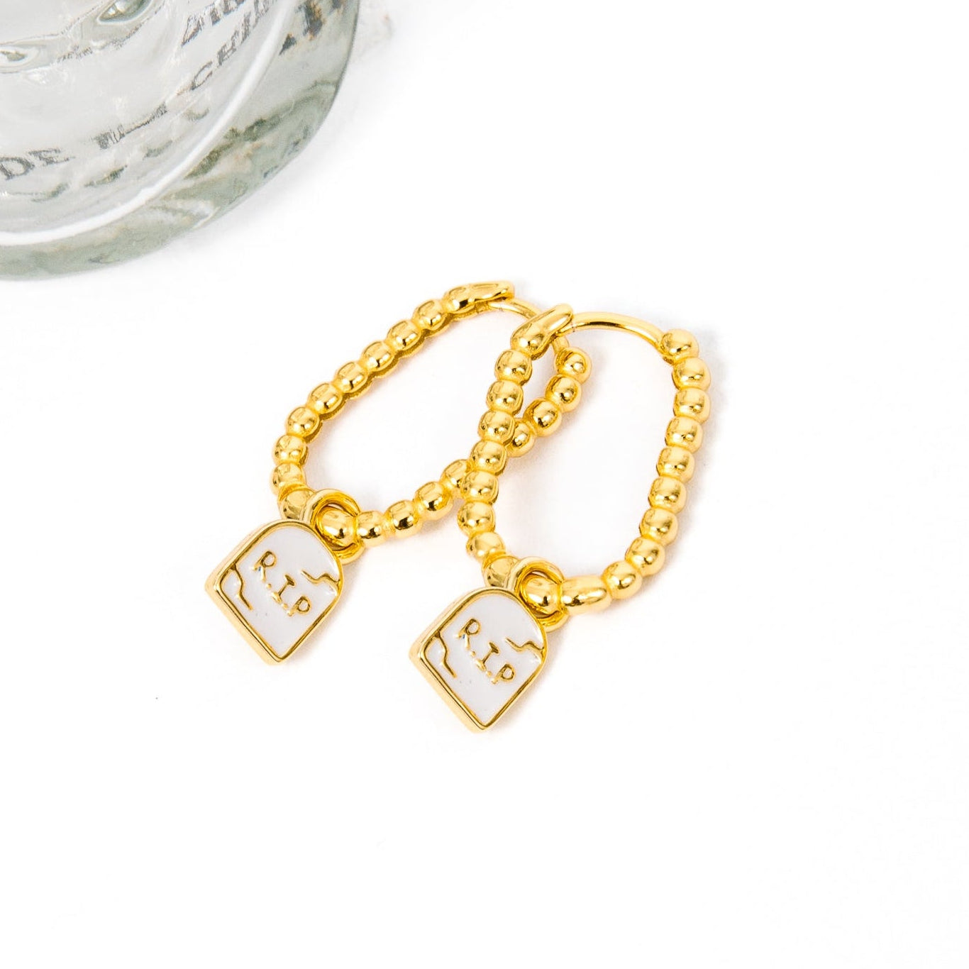 A pair of gold chain earrings with tombstone, displayed on a white background.