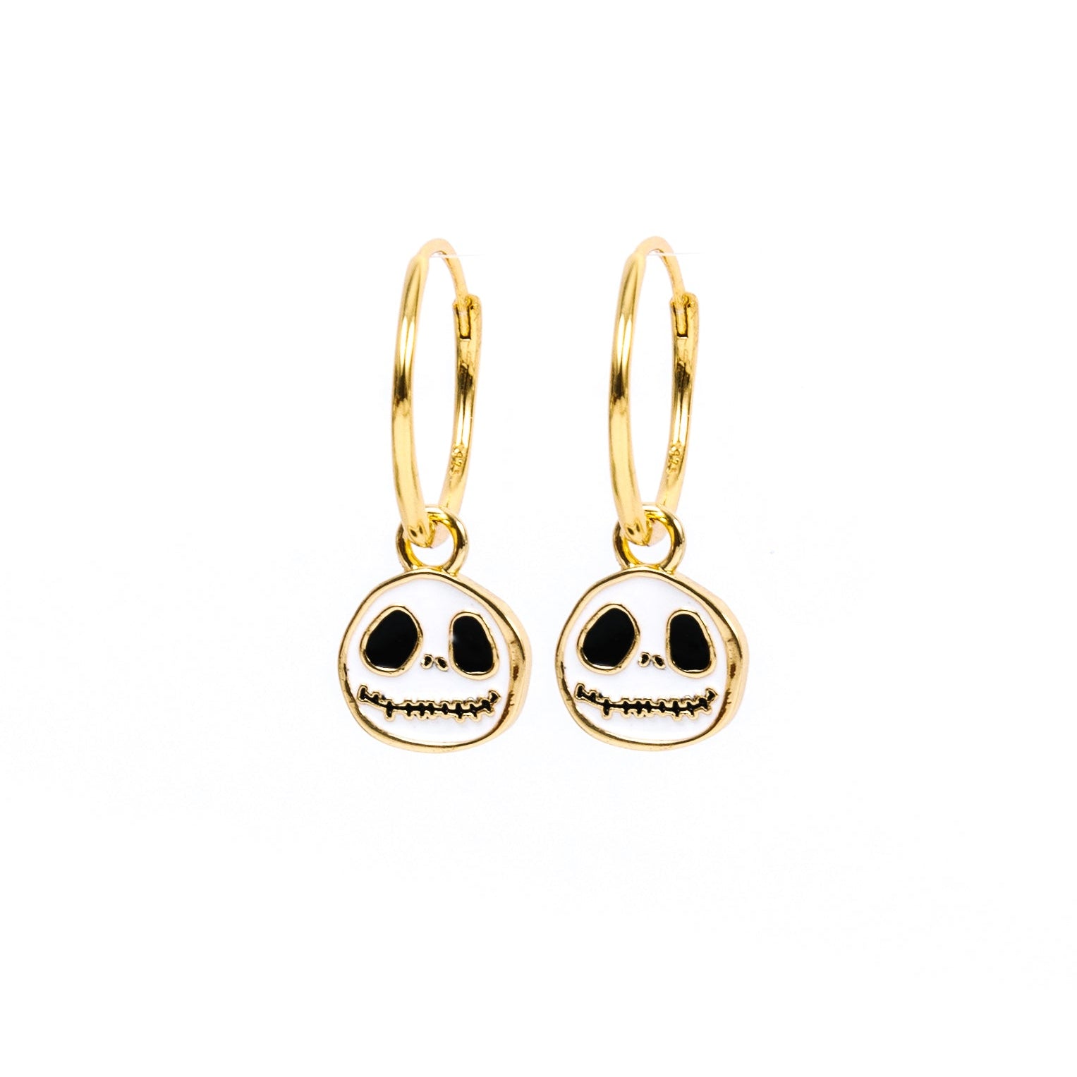 A pair of gold hoop earrings with Jack Skellington skull charms, shown on a plain white background.