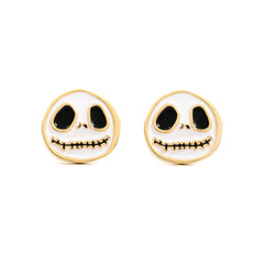 A pair of skull-shaped stud earrings with a white enamel face, black eyes and mouth details, and a gold-tone border, shown on a plain white background.