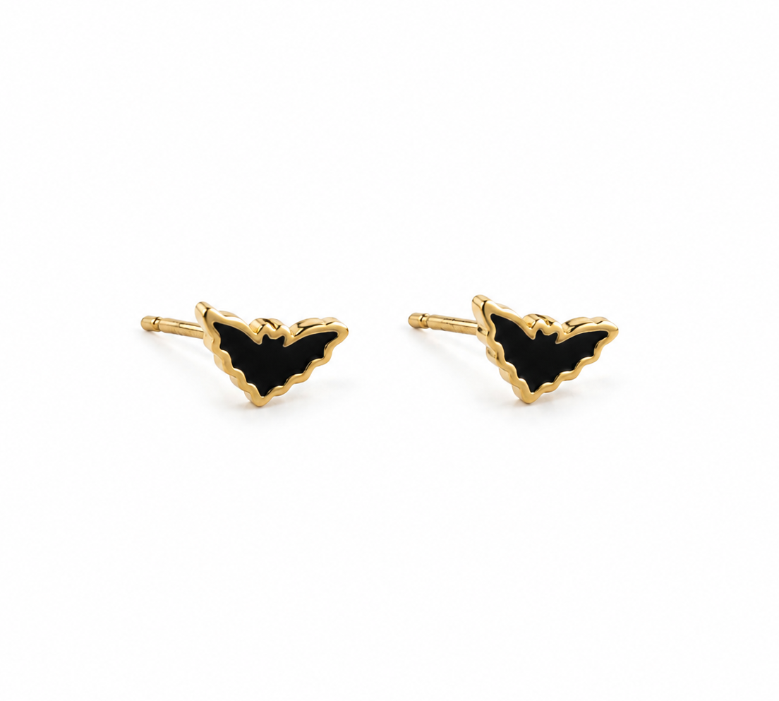 A pair of gold bat stud earrings with black enamel fill, shown on a plain white background.